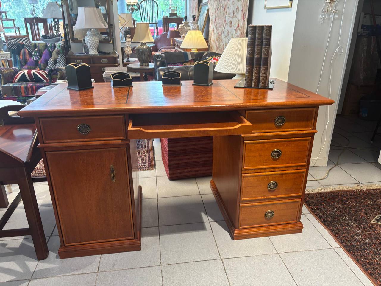 Wooden desk with drawers in a room with furniture and decor.